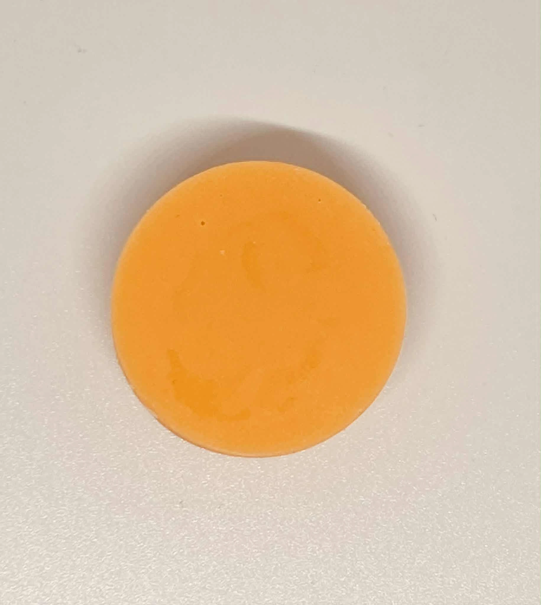 Étiquette du fondant parfumé 'Monoï de Tahiti' à la cire de soja. L'illustration est une photo d'un tube de crème solaire sur le sable, évoquant le parfum solaire et exotique des vacances