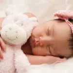 Étiquette du fondant parfumé 'Mon doudou' des Senteurs de Pasithéa, à la cire de soja et fragrance de Grasse. L'image montre un bébé endormi avec son doudou ours.