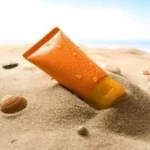 Étiquette du fondant parfumé 'Monoï de Tahiti' à la cire de soja. L'illustration est une photo d'un tube de crème solaire sur le sable, évoquant le parfum solaire et exotique des vacances